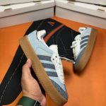 Adidas Sambae X Atmos Denin First Copy Shoes in denim blue with gum sole held in hand in front of Adidas shoe boxes