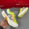 New Balance FuelCell SuperComp Elite v3 running shoe with lime yellow, white, grey, and orange details, featuring vibrant upper and performance sole."