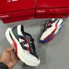 New Balance FuelCell SuperComp Elite v3 in white, black, red, and blue colorway, presented with bold black logo and red FuelCell shoebox packaging.