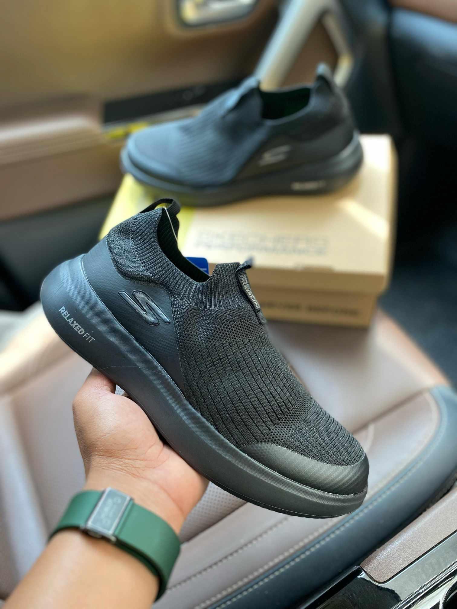 Skechers Relaxed Fit Black First Copy Shoes held in hand with box in background